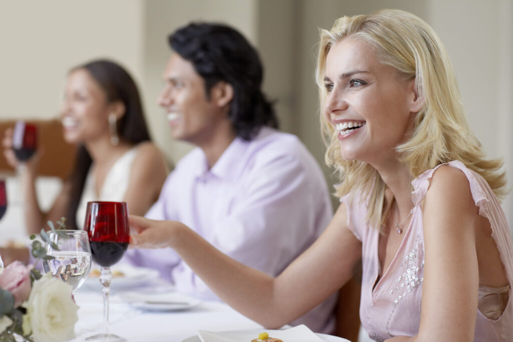 Cheerful Young Woman Enjoying Dinner Party With Friends
